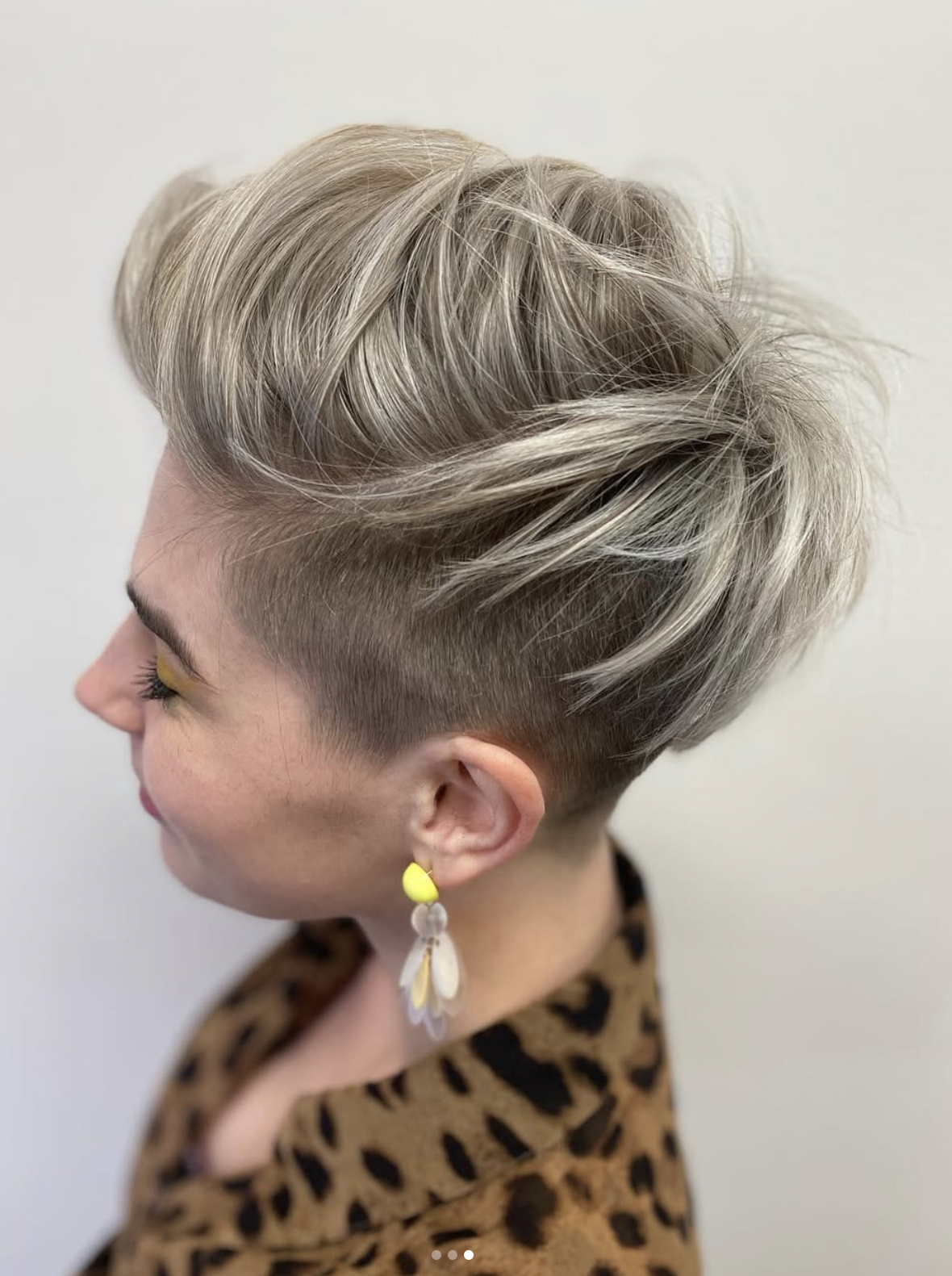 Short platinum pixie with an undercut and yellow eyeshadow