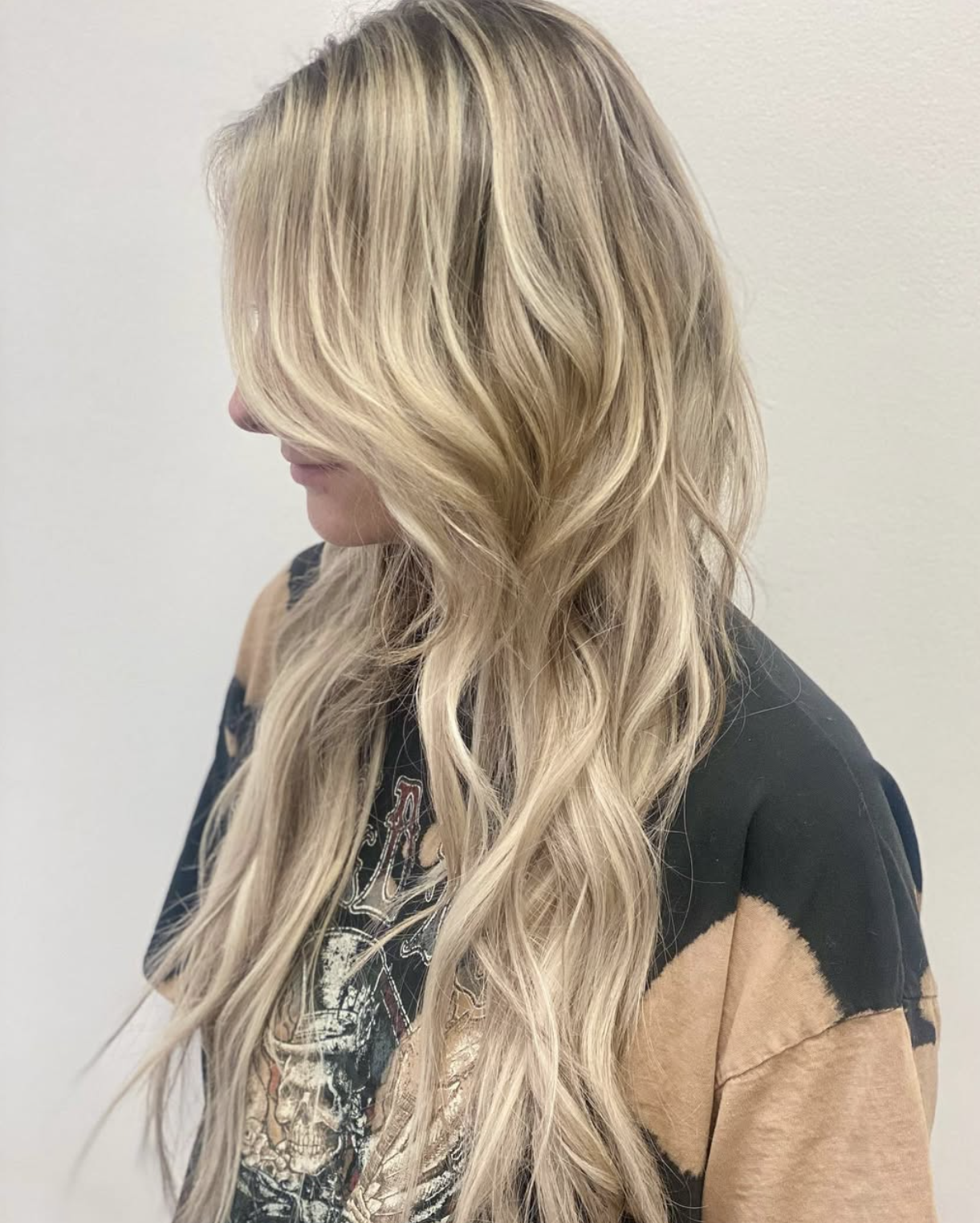 Long honey-blonde layered hair with soft beach waves